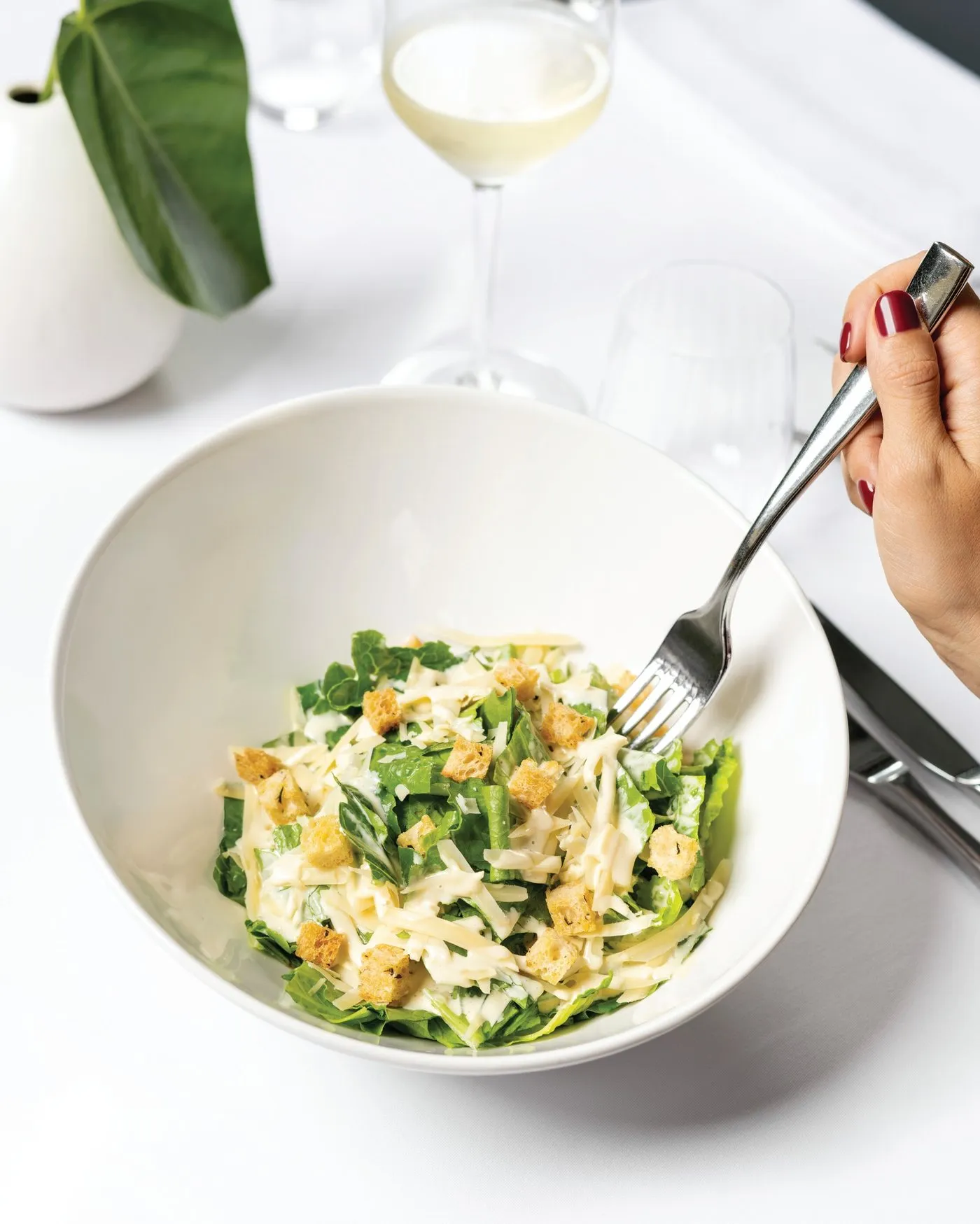 Ensalada césar con crutones y parmesano en un tazón blanco
