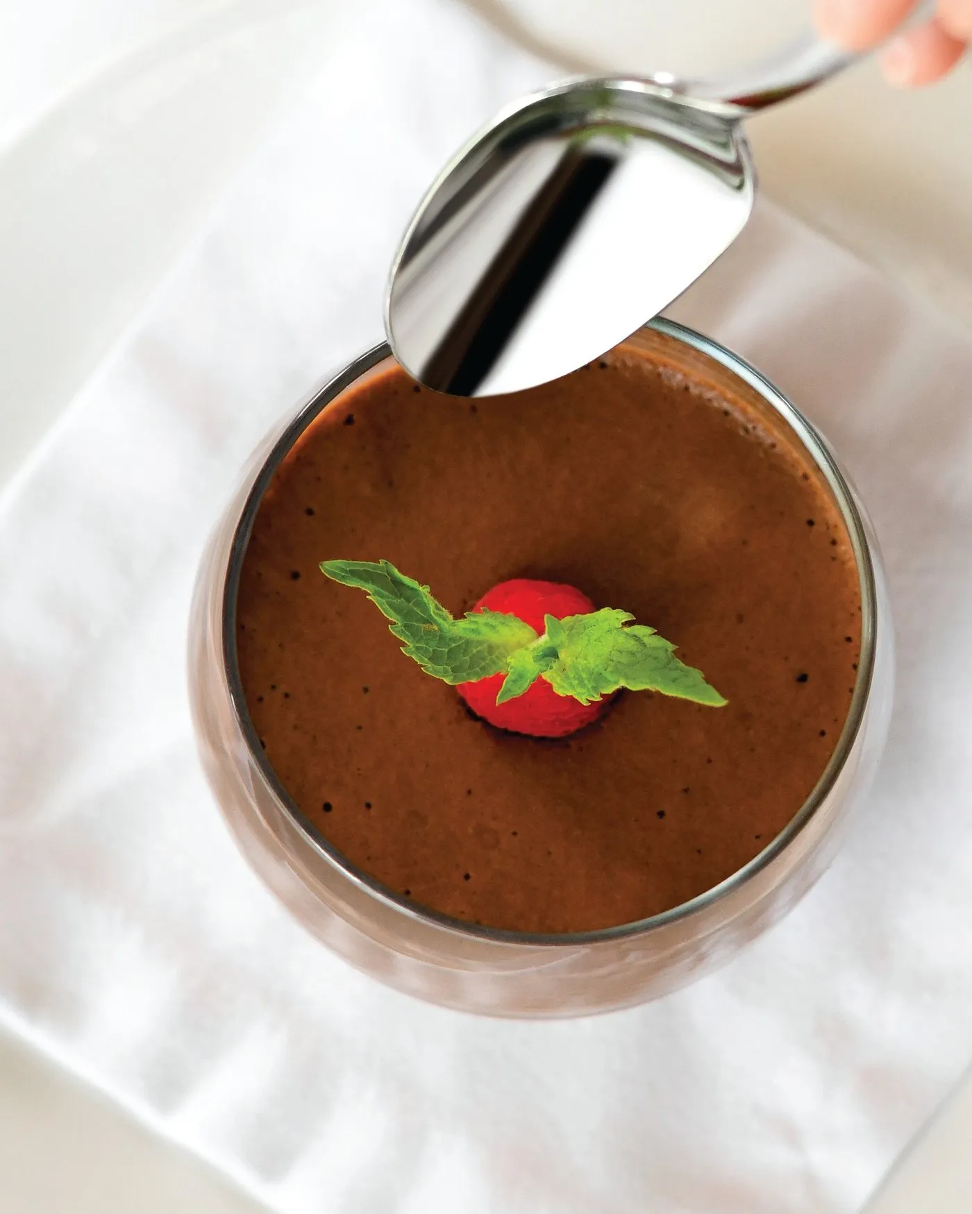 Mousse de chocolate en copa, decorada con una fresa y hojas de menta
